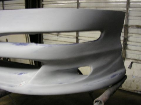 1994 Ford Probe - Close-up of a car bumper, likely undergoing preparation for painting.