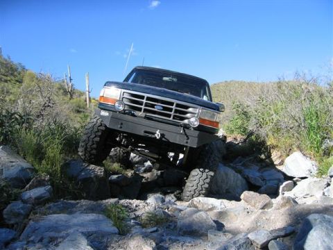 1994 Ford Bronco - This 1994 Ford Bronco tackles a challenging rocky trail under a clear blue sky.