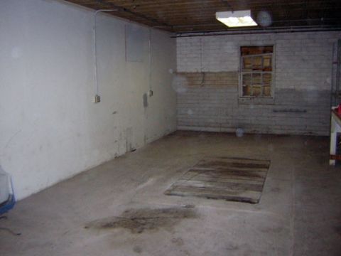 1995 Ford Bronco - This is a scene of an empty room with a wooden panel on the floor and a window covered with boards.