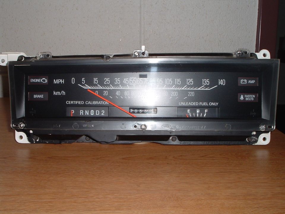 Ford 140 MPH ribbon speedometer cluster on a wood table, front view