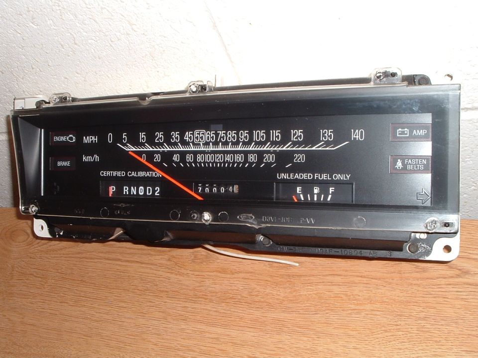 Ford 140 MPH instrument cluster removed from the dash, sitting on a wood table