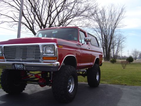 1978 Ford Bronco - This red 1978 Ford Bronco is lifted and sits on large tires.