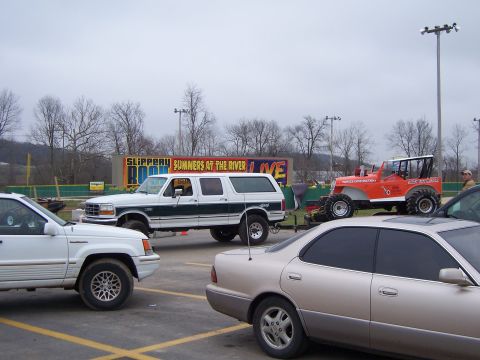 1992 Ford C-250 (Centurion Conversions) - A white and green Ford C-250 Centurion conversion SUV is parked in a lot with other vehicles.
