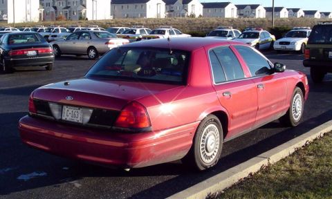1999 Ford Crown Victoria - This 1999 Ford Crown Victoria police car is seen from the rear in a parking lot with other vehicles.