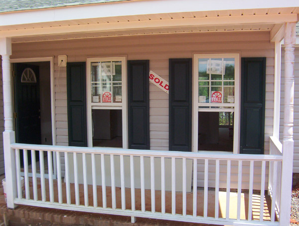 House with a porch, two windows with 'SOLD' signs, and a 'SUPER MOTORS' watermark