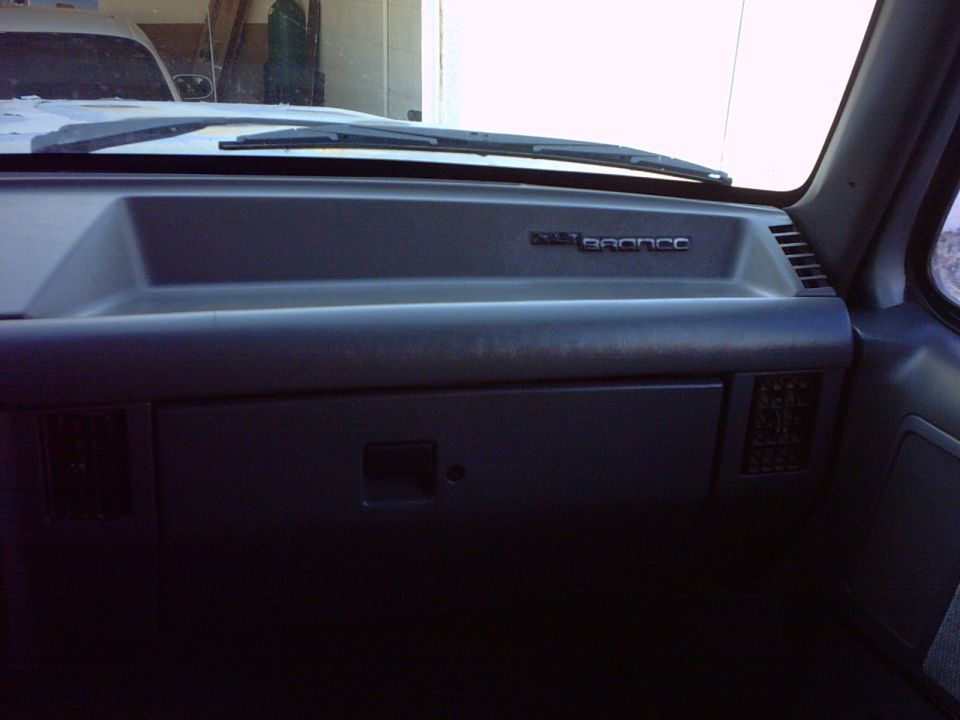 Dashboard of a 1990 Ford Bronco with 'BRONCO' badge visible
