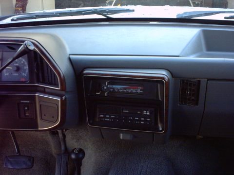 1990 Ford Bronco - The interior dashboard of a 1990 Ford Bronco, wood trim accents around the radio and instrument cluster.