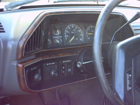 1990 Ford Bronco - The dashboard interior shows wood grain trim and a speedometer indicating 60 mph.