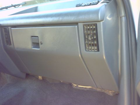 1990 Ford Bronco - Interior view of a 1990 Ford Bronco, focusing on the glove compartment and dashboard details.
