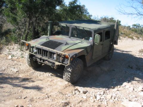 1996 Ford Bronco - This Humvee is shown in a three-quarter front view on a dusty, off-road path.