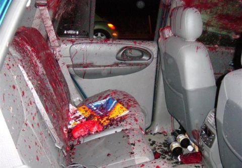 1996 Ford Bronco - Vehicle interior heavily contaminated with blood, with bottles and debris scattered on the floor.