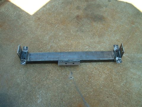 1995 Ford Bronco - Custom steel bracket with welded mounting tabs sits on concrete.