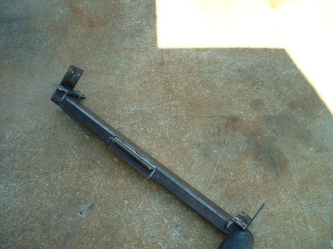 1995 Ford Bronco - A custom-fabricated metal component rests on a concrete surface, showing signs of welding.