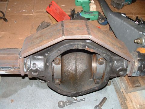 1995 Ford Bronco - Differential housing with a custom metal cover, likely for off-road modification, with tools visible in the background.