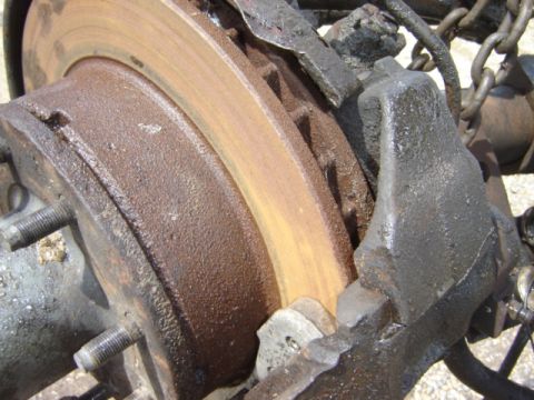 1992 Ford Bronco - This photo shows a close-up view of a heavily rusted vehicle brake rotor and caliper assembly.