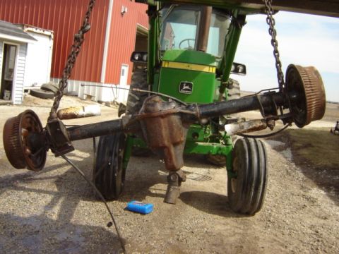 1992 Ford Bronco - A John Deere tractor's rear axle is suspended by chains, undergoing maintenance or repair.