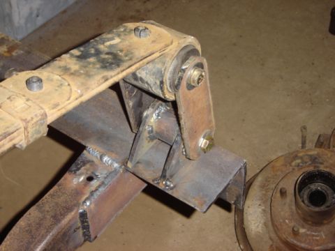 1992 Ford Bronco - Close-up of a vehicle's suspension system, showing a leaf spring and custom metalwork.