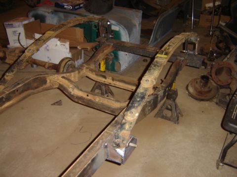 1992 Ford Bronco - Vehicle frame and suspension components are shown on jack stands in a workshop setting.