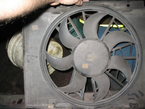 1986 Ford Bronco - A person is holding a radiator fan assembly, showing its blades and housing.