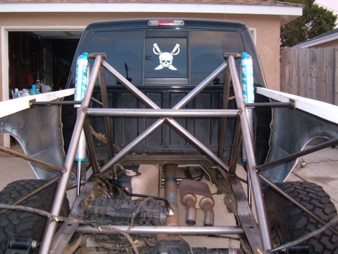 2002 Ford Ranger - This modified pickup truck features a custom roll cage and suspension system, with a pirate skull sticker on the rear window.