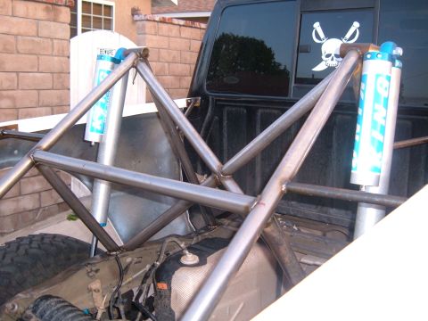 2002 Ford Ranger - Pickup truck bed modified with a custom roll cage and external suspension components.