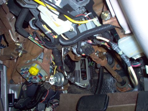 1994 Ford Crown Victoria - This photo shows the complex wiring and steering column components located beneath the dashboard of a vehicle.