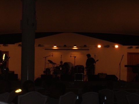 1988 Ford Bronco - A band plays on stage at an outdoor venue at night, with lighting and musical equipment.