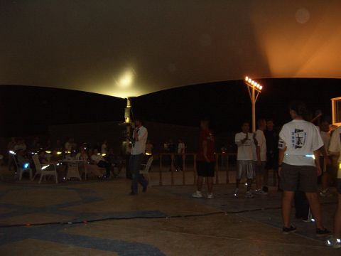 1988 Ford Bronco - An outdoor event is underway with attendees mingling under artificial lighting and a large overhead structure.