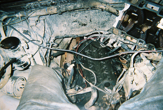 Engine bay with hoses, wires, and engine block visible. Looks like it needs some work