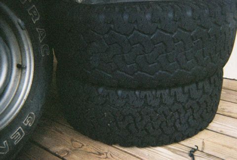 1988 Ford Bronco - A close-up view of stacked tires, with visible tread patterns and some text on the sidewall of one tire.