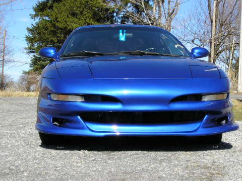 1994 Ford Probe - The front end of a blue 1994 Ford Probe is shown in a head-on view, parked outdoors.