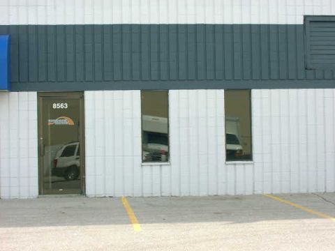 1999 Jeep Grand Cherokee - A white SUV is visible through the glass door of a building with the address 8563.
