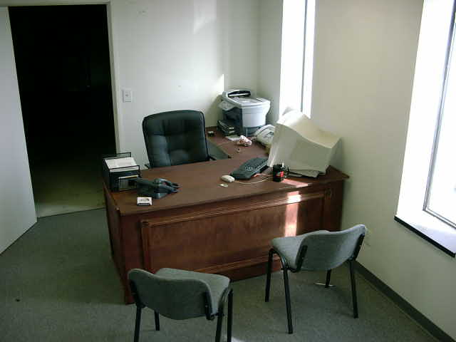 Office desk with computer, chairs, and telephone