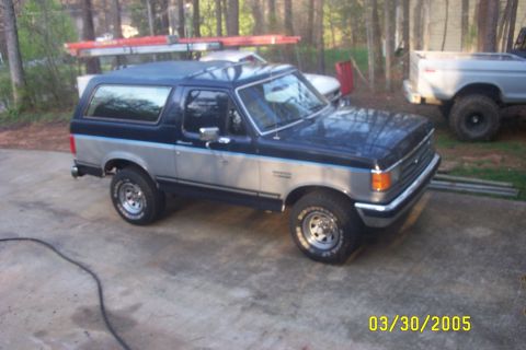 1979 Ford F-150 - Ford Bronco parked outdoors with a ladder rack on the roof. A second truck is visible in the background.