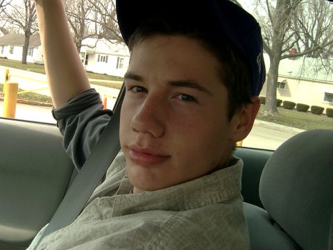 1998 Jeep TJ - A young person is seen from the chest up, looking towards the camera while sitting in the passenger seat of a vehicle.