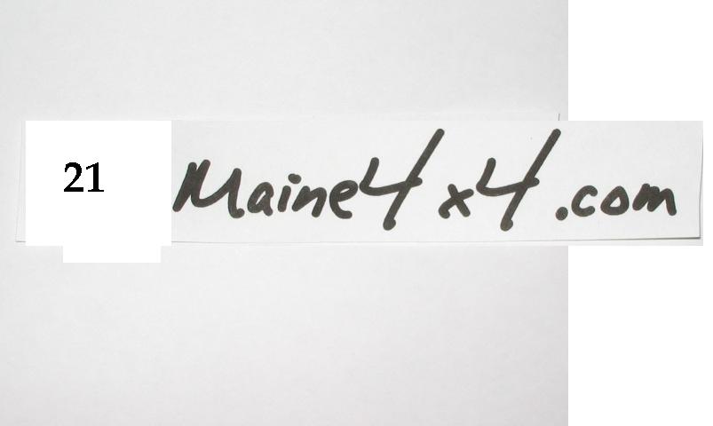 Paper strip with handwritten text "Maine4x4.com" and number 21. Supermotors.net logo at bottom right