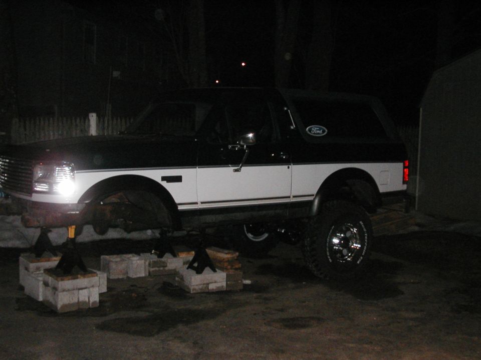 Two-tone 1994 Ford Bronco on jack stands, front end raised