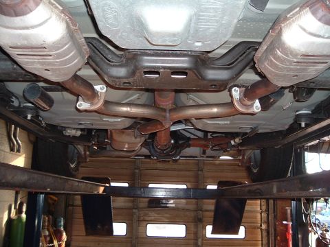 2000 Ford Crown Victoria - The undercarriage of a vehicle is shown from below, with the exhaust system and rear differential visible.