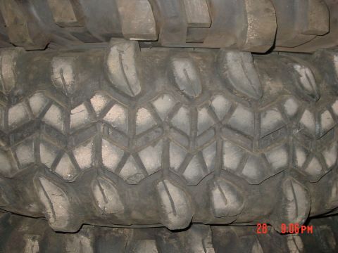 1995 Ford Bronco - Close-up of aggressive off-road tire treads stacked together, showing chunky lug patterns typical of a mud-terrain tire (likely a TSL/Super…