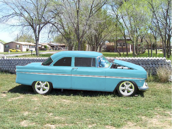 Turquoise 1950s Ford two-door sedan hot rod on mag wheels, side view