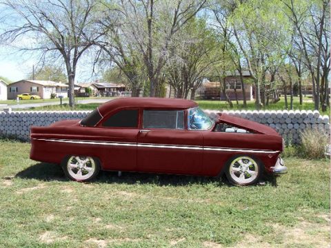 1955 Ford Customline - This 1955 Ford Customline is shown from the side with its hood raised, revealing the engine compartment.