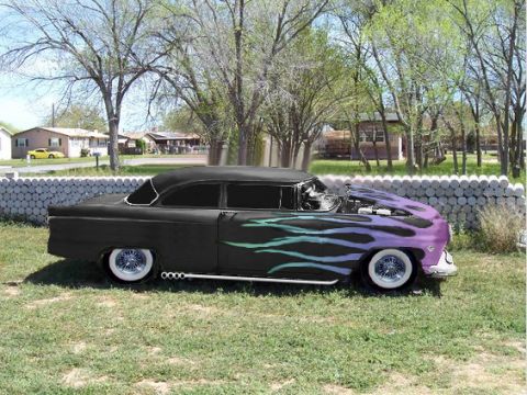 1955 Ford Customline - A customized 1955 Ford Customline with flame graphics and exposed engine sits in a grassy yard.
