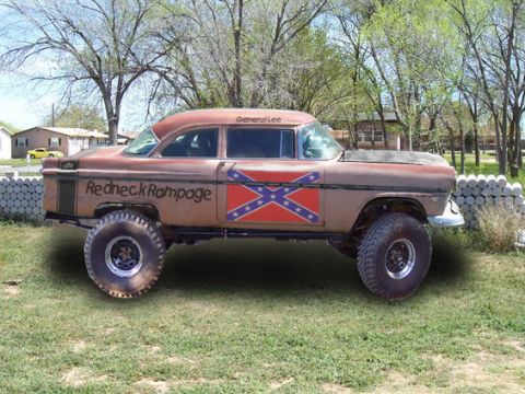 1955 Ford Customline - A heavily modified 1955 Ford Customline, also known as the "General Lee," is shown lifted with large off-road tires and custom decals.