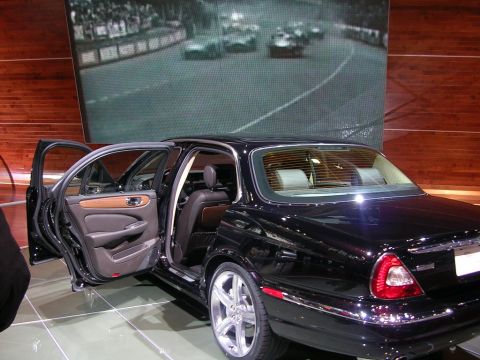 2000 Pontiac Trans Am - A black Jaguar sedan is displayed with its doors open, revealing its interior details.