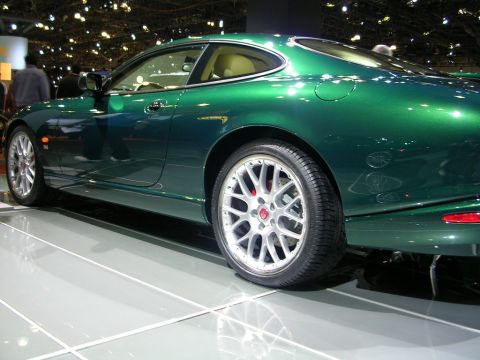 2000 Pontiac Trans Am - A green Jaguar coupe is displayed indoors, with its distinctive wheels and interior visible.