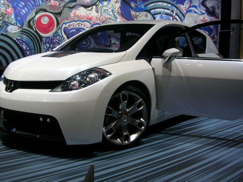 2000 Pontiac Trans Am - A white concept car is displayed with its driver's door open, set against a colorful mural.