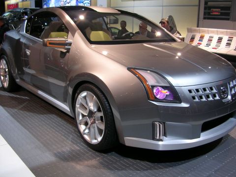 2000 Pontiac Trans Am - A silver concept car is displayed at an auto show, a distinctive front grille and purple-accented headlights.