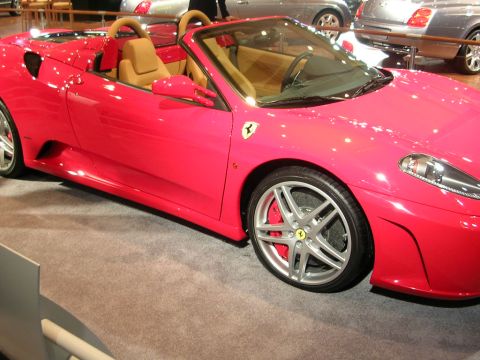2000 Pontiac Trans Am - A bright pink Ferrari F430 Spider convertible is displayed indoors, showing its tan interior and distinctive front wheel.