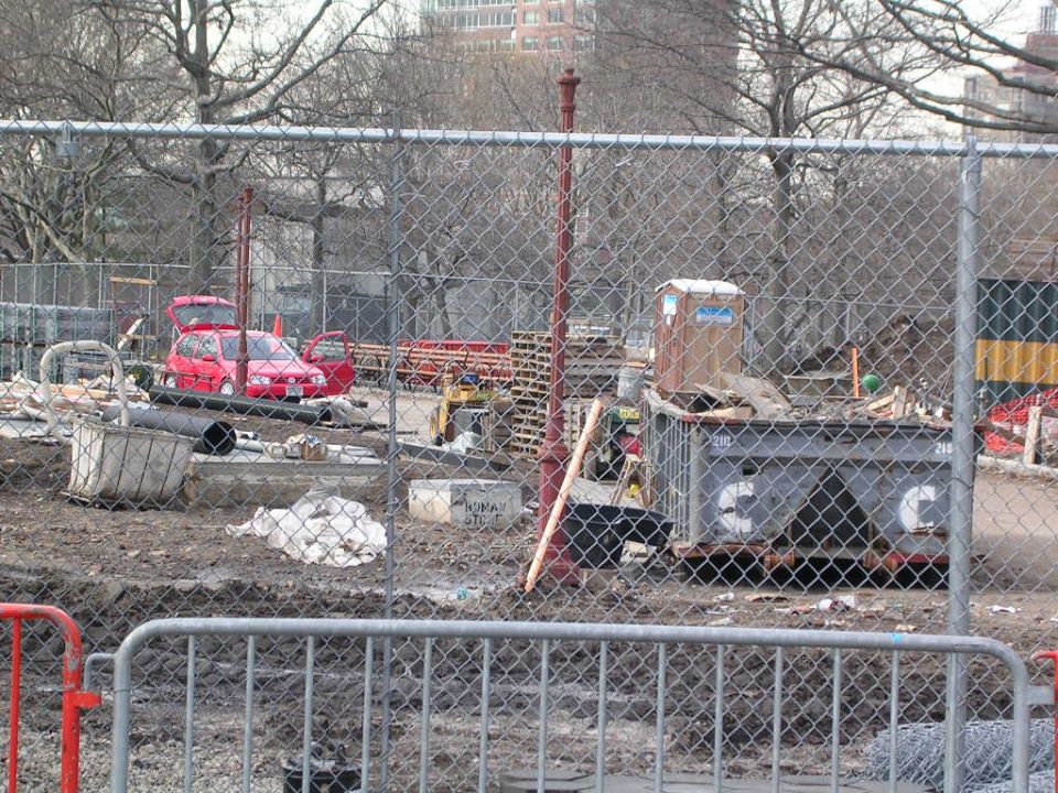 Red hatchback with doors and trunk open at a construction site