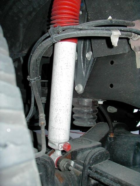 2002 Ford Excursion - Close-up view of the rear suspension system, focusing on the shock absorber and associated components.